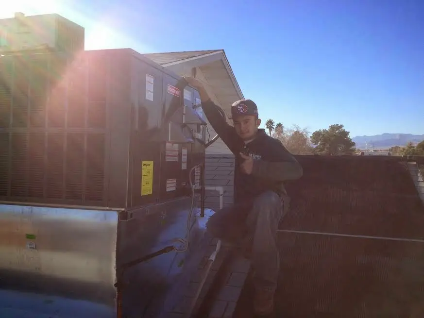 HVAC technician performing Heat Pump Repair on a rooftop unit in Dundee